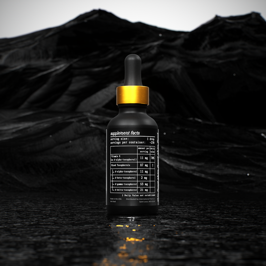 Black dropper bottle with gold cap on a black textured background