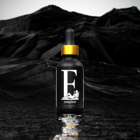 Black dropper bottle with gold cap on a black textured background